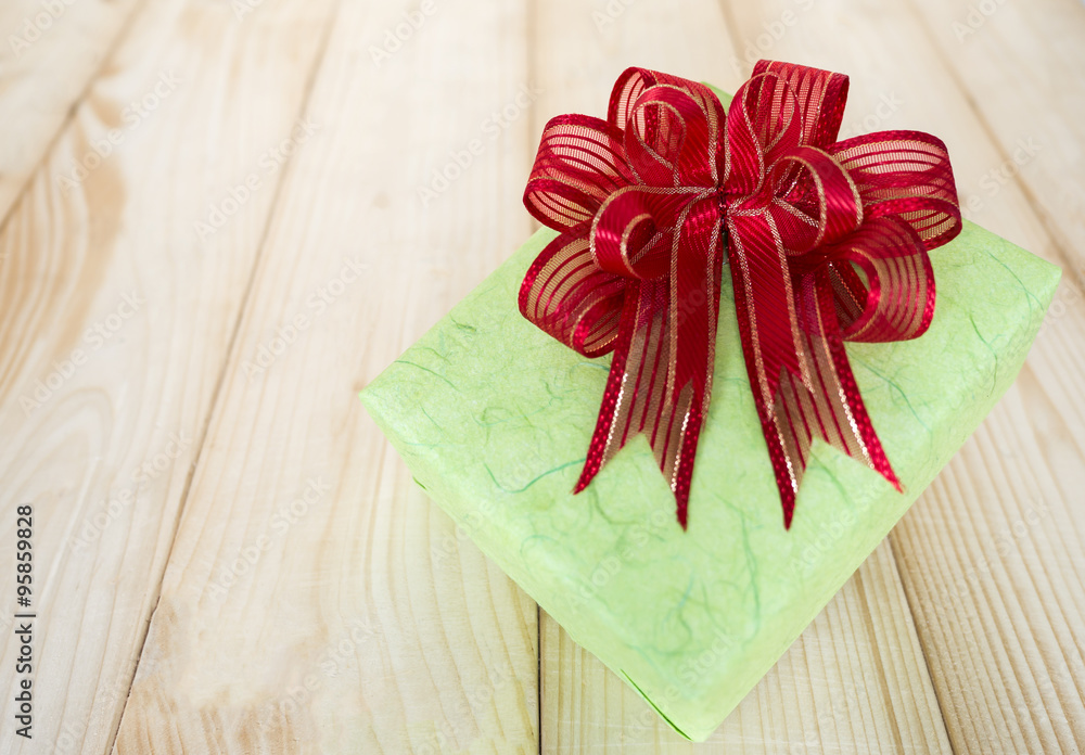 gift box 1 - one green gift box and red bow on wood background