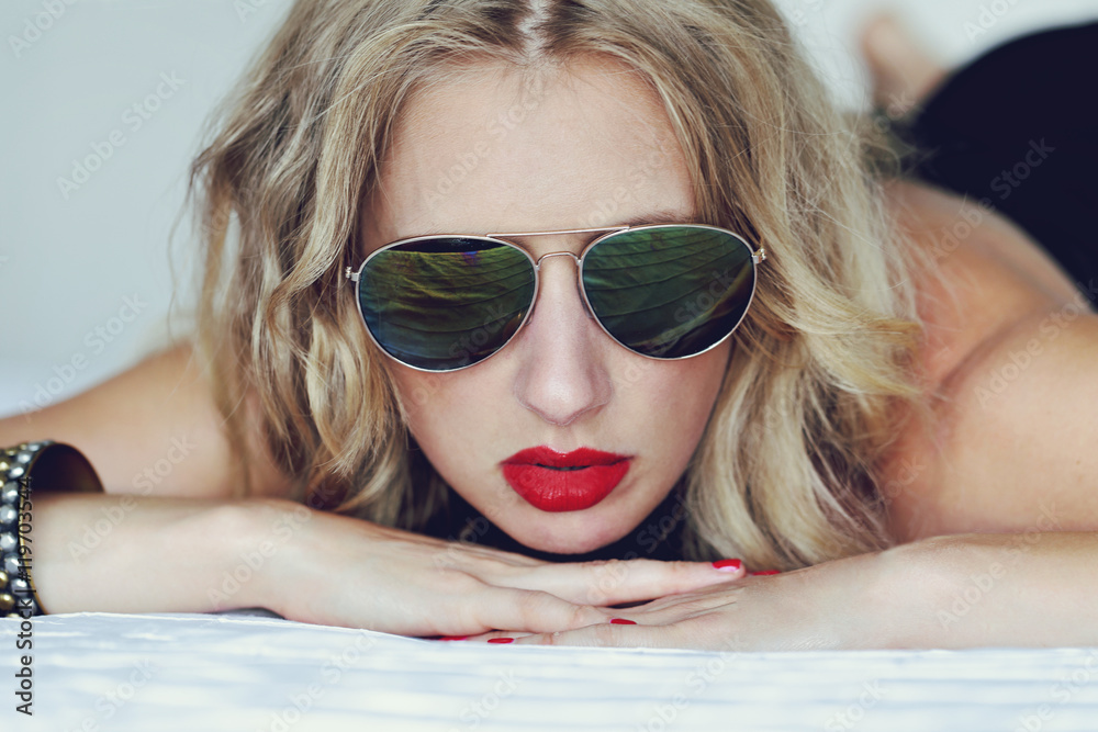 femme sexy et glamour dans un lit en lingerie avec lunettes vintage style années Stock