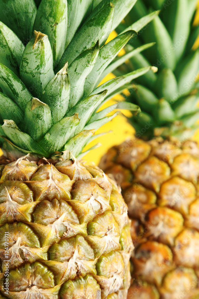 Ripe pineapples on a yellow wooden background