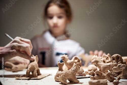 girl molds a seal from the clay, the teacher helps her. Blurred Background