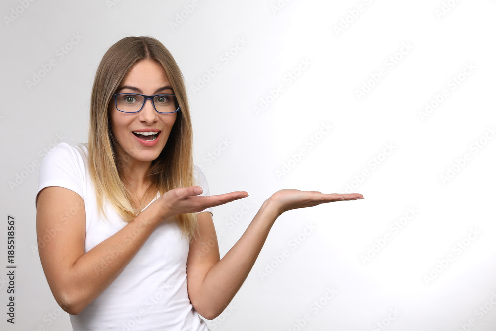 Hübsche blonde Frau mit Brille lacht und zeigt in eine Richtung Stock