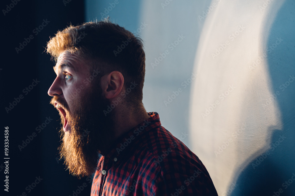 Angry Horror Beard Man With Open Mouth Crying In A Dark And Low Light