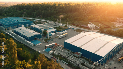 Aerial view of warehouse storages or industrial factory or logistics center from above. Aerial view of industrial buildings at sunset