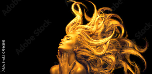 Gold Woman. Beauty fashion model girl with Golden make up, Long hair on black background. Gold glowing skin and fluttering hair. Metallic, glance Fashion art portrait, Hairstyle. Fashion art design