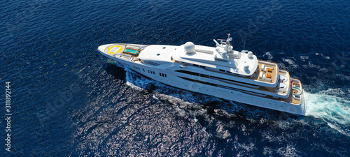 Aerial drone ultra wide photo of luxury mega yacht with wooden deck cruising Aegean deep blue sea