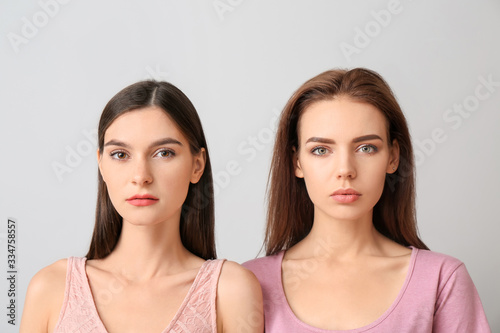 Young women with beautiful makeup on light background