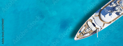 Aerial drone top down ultra wide photo with copy space of luxury yacht anchored in tropical exotic island turquoise sea