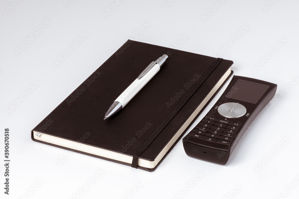 Foto de Carnet de note noir avec un stylo et un téléphone posés do