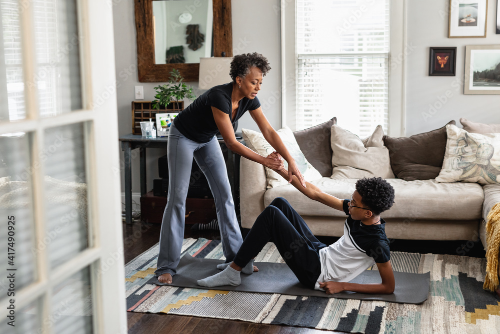 Black Mom Helps Son Up Off The Floor After At Home Workout Exercise