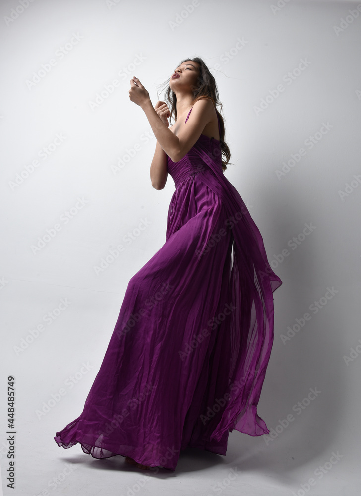 Full Length Portrait Of Pretty Brunette Asian Girl Wearing Purple Flowing Gown Standing Pose In