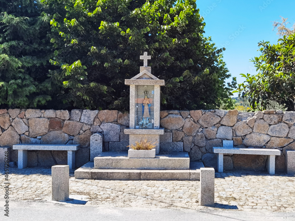 Monumento religioso alguns bancos de pedra à sua volta na aldeia de