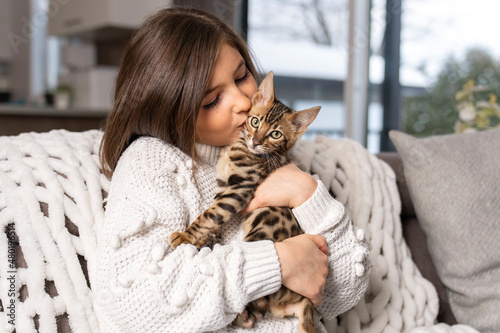 Bengal cat in the living room on the couch with child