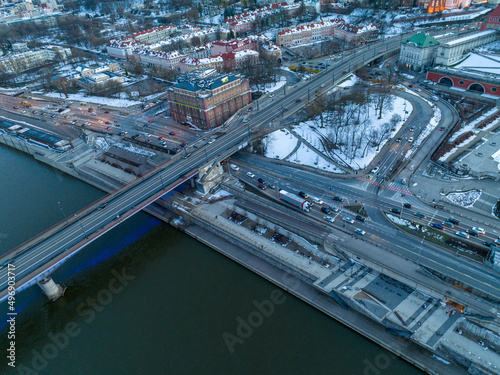 Duża rzeka widziana z drona podczas zachodu słońca, Warszawa, widoczne zabudowania i brzeg, mosty