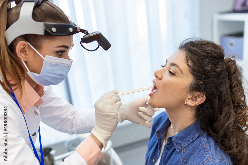 Female Patient Opening Her Mouth For The Doctor To Look In Her Throat