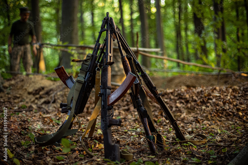 Five Ak Kalashnikov Assault Rifles Stand Together On The Ground In