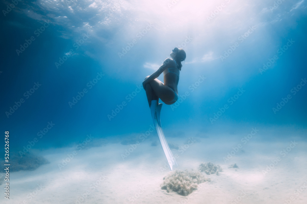 Lady Freediver In Bikini Posing Underwater Over Sandy Sea Bottom With