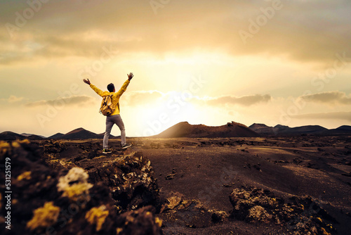 Happy man with arms up on a mountain at sunset - Traveler with backpack hiking nature - Motivational picture, sport lifestyle and successful concept