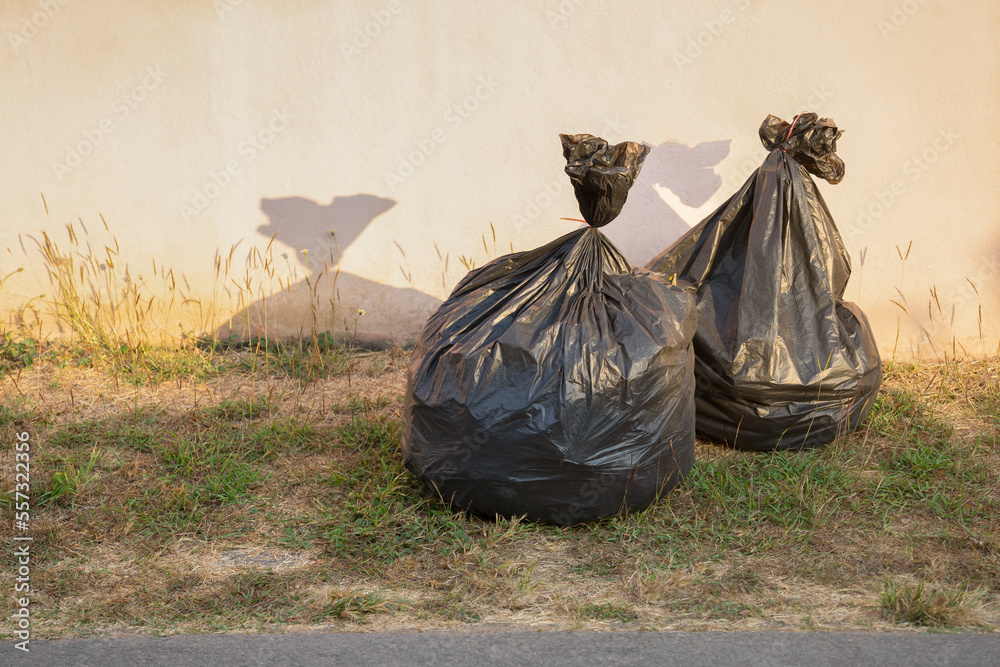 Black Garbage Bags On Grasses At Side Road Beside The House Waiting For