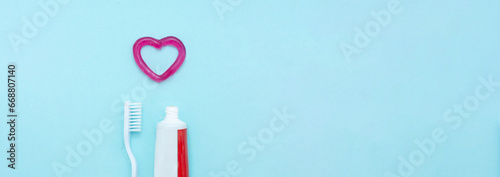 Closeup of a toothpaste, toothbrush and toothpaste heart on blurred blue background.Professional Dental concept.