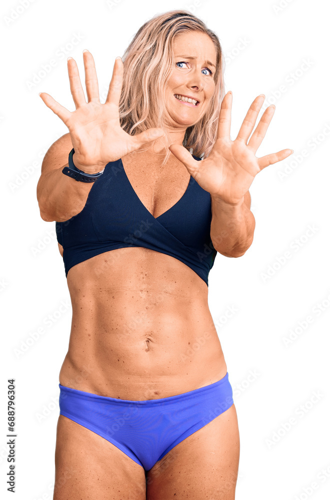 Middle Age Fit Blonde Woman Wearing Bikini Afraid And Terrified With