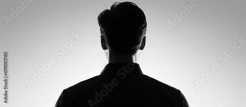 Man's silhouette with back turned, against white background.