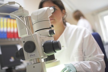 scientist using microscope in office