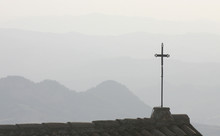 Silhouetted Cross On A Roof