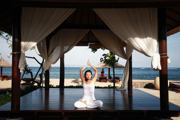 asian woman meditating by the beach