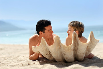 romantic couple on the beach behind the seashell