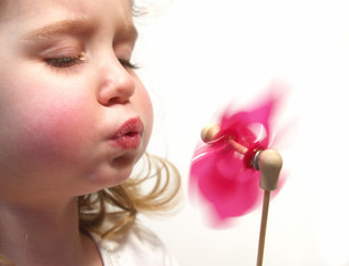 girl blowing pinwheel