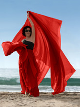 Woman On The Beach With A Red Scarf