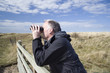 man birdwatching through binoculars