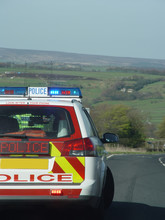 Police Car And Slow Sign