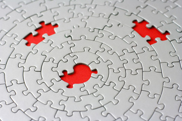 three missing pieces in a grey jigsaw