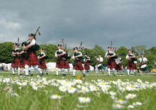 Scottish Pipe Band Marching On The Grass