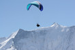 paraglider above snow capped peaks