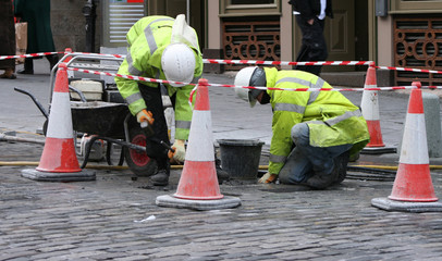 two workman repairing pavement