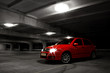 red hatchback car on black and white background