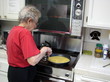 senior female cooking eggs