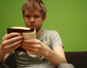 Wall Mural - young man reading small bible