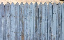 The Top Of A Blue Wooden Fence