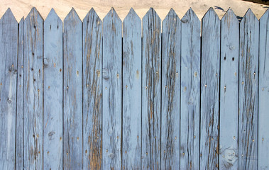 the top of a blue wooden fence