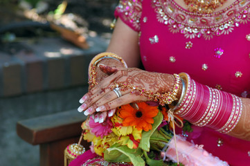 hands of a indian bride with henna design and bang