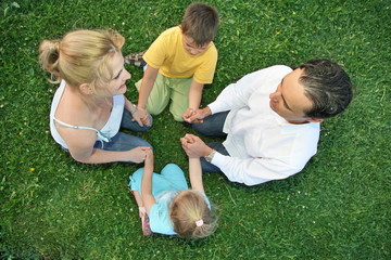 Wall Mural - family sitting on a grass