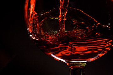 red wine pours into a glass