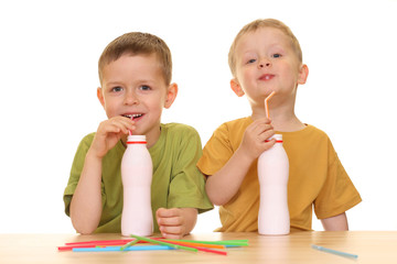 five and three years old boys drinking milk isolated on white