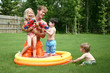 © Ixepop - Boys and girl play with dad in the kiddie pool with water guns