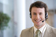 © carlosseller - Young smiling businessman on headset