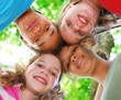© Elenathewise - Faces of four happy young girls shot from below