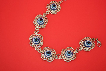 Poster - Metallic bracelet talisman with blue eyes for helping.